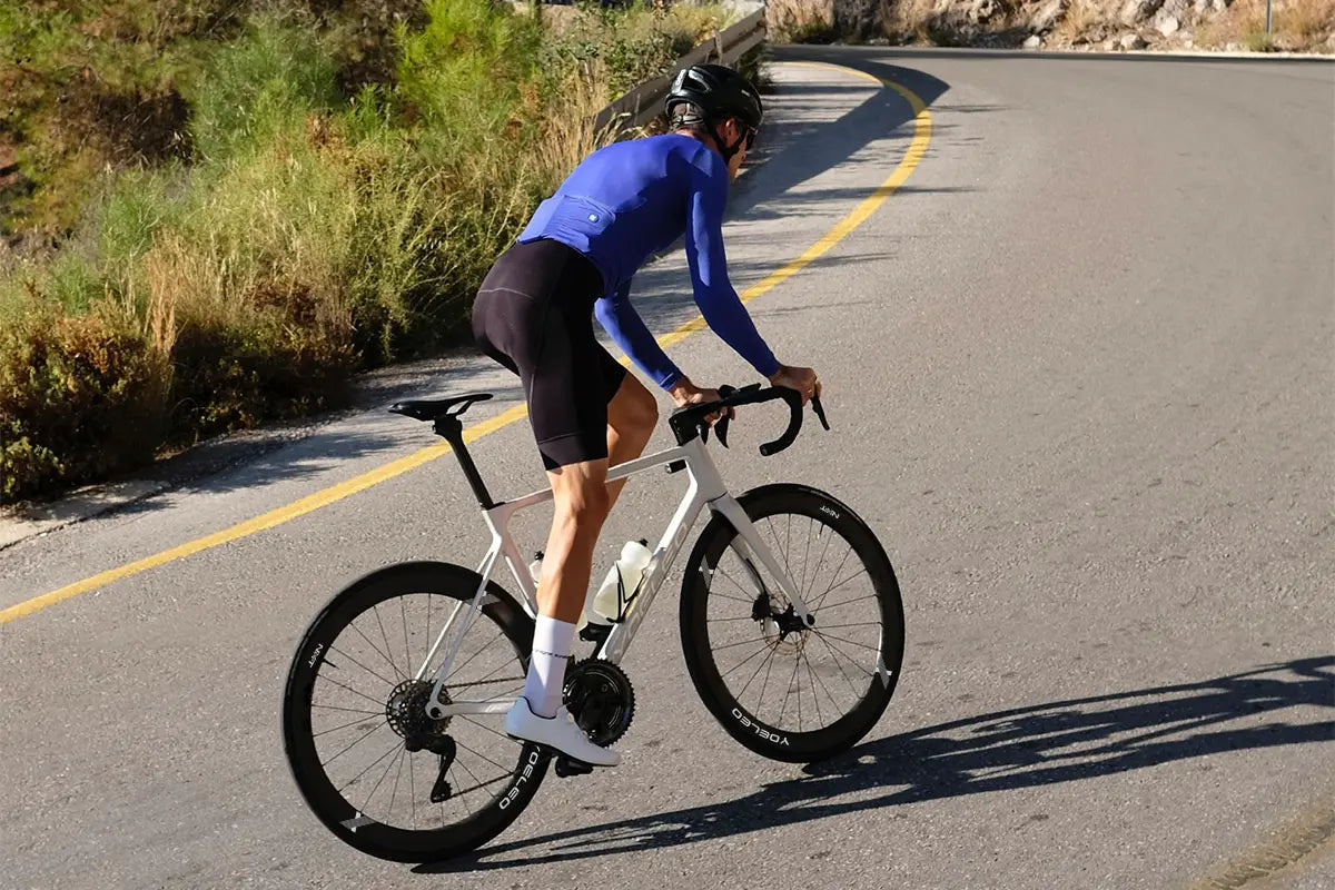 Cyclist climbing out of the saddle on Yoeleo carbon wheelset showing rotating mass benefit