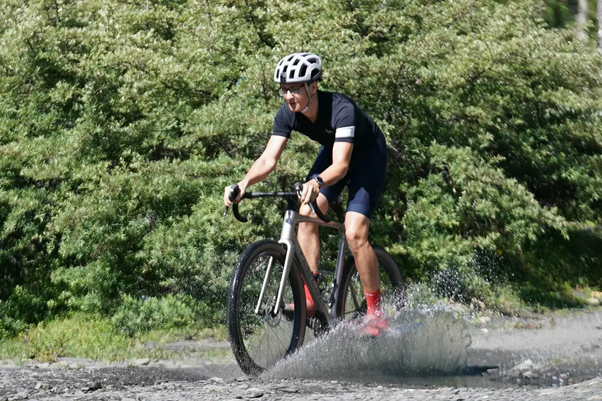 Gravel rider pushing through water puddle
